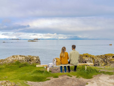 golf course, couple on a banch, ocean, coast, holidays in scotland, golf vacation
