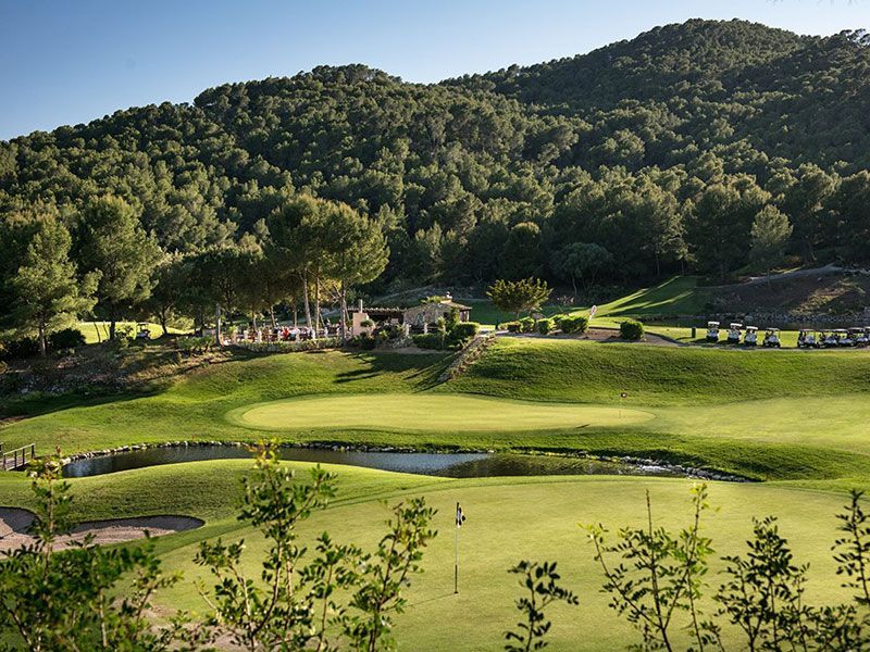  Golf de Andratx, golfplatz, hügelige fairways, see, haus im hintergrund, berg von bäumen bewachsen 